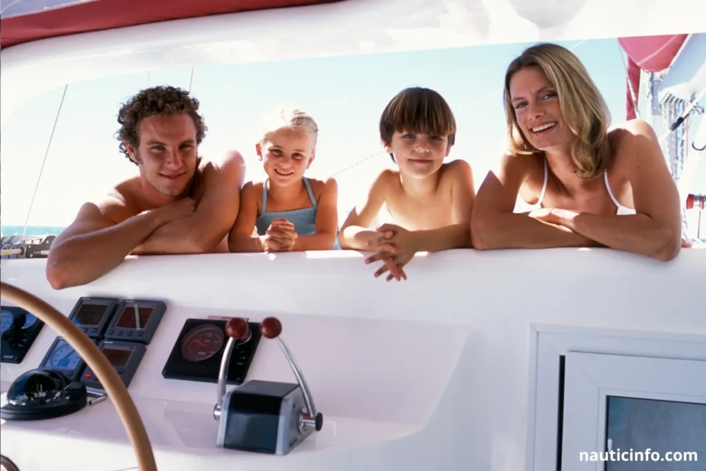 Famille profitant du coucher de soleil sur le trampoline d'un catamaran au mouillage lors d'un tour du monde.